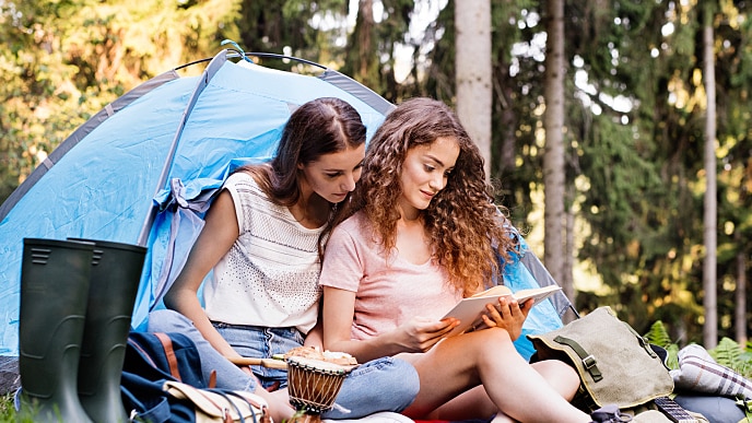 Zwei Mädchen lesen gemeinsam im Campingplatz
